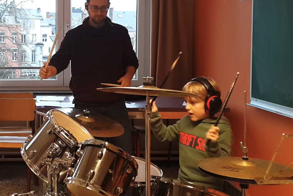 Enfant qui improvise un rythme à la batterie